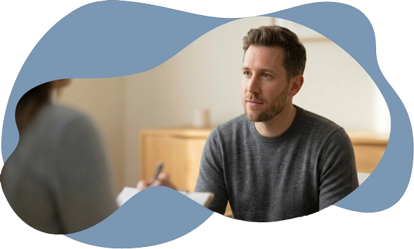 A man participating in a clinical consultation with a psychologist, representing a comprehensive
mental health evaluation to identify root causes and provide a formal diagnosis for insurance and
recovery.